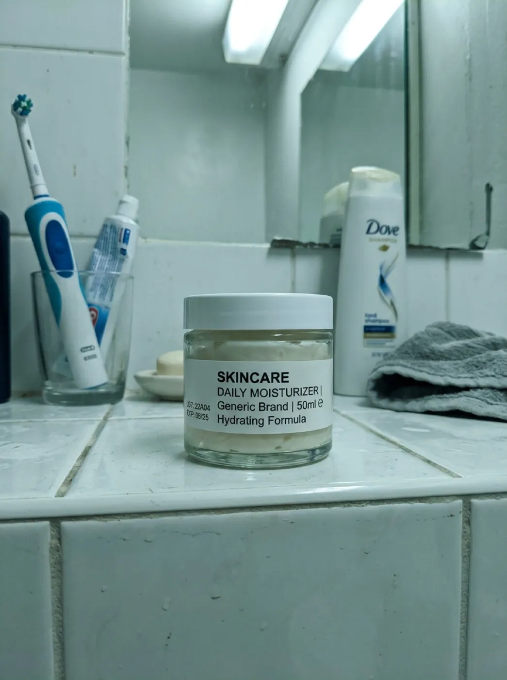 Стеклянная баночка увлажняющего крема, снятая на телефон на полке в ванной