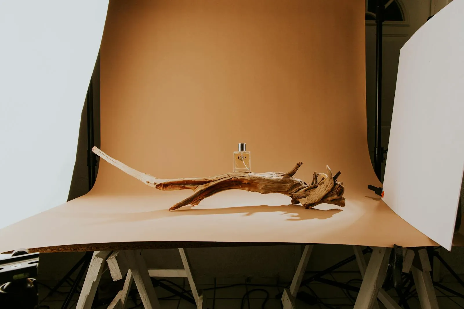 Студийная съёмка товара: парфюм на декоративной подставке из дерева